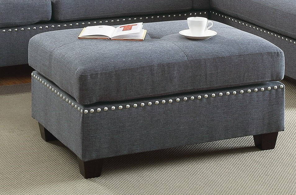 Tufted charcoal fabric ottoman with silver nailhead trim and dark wood legs