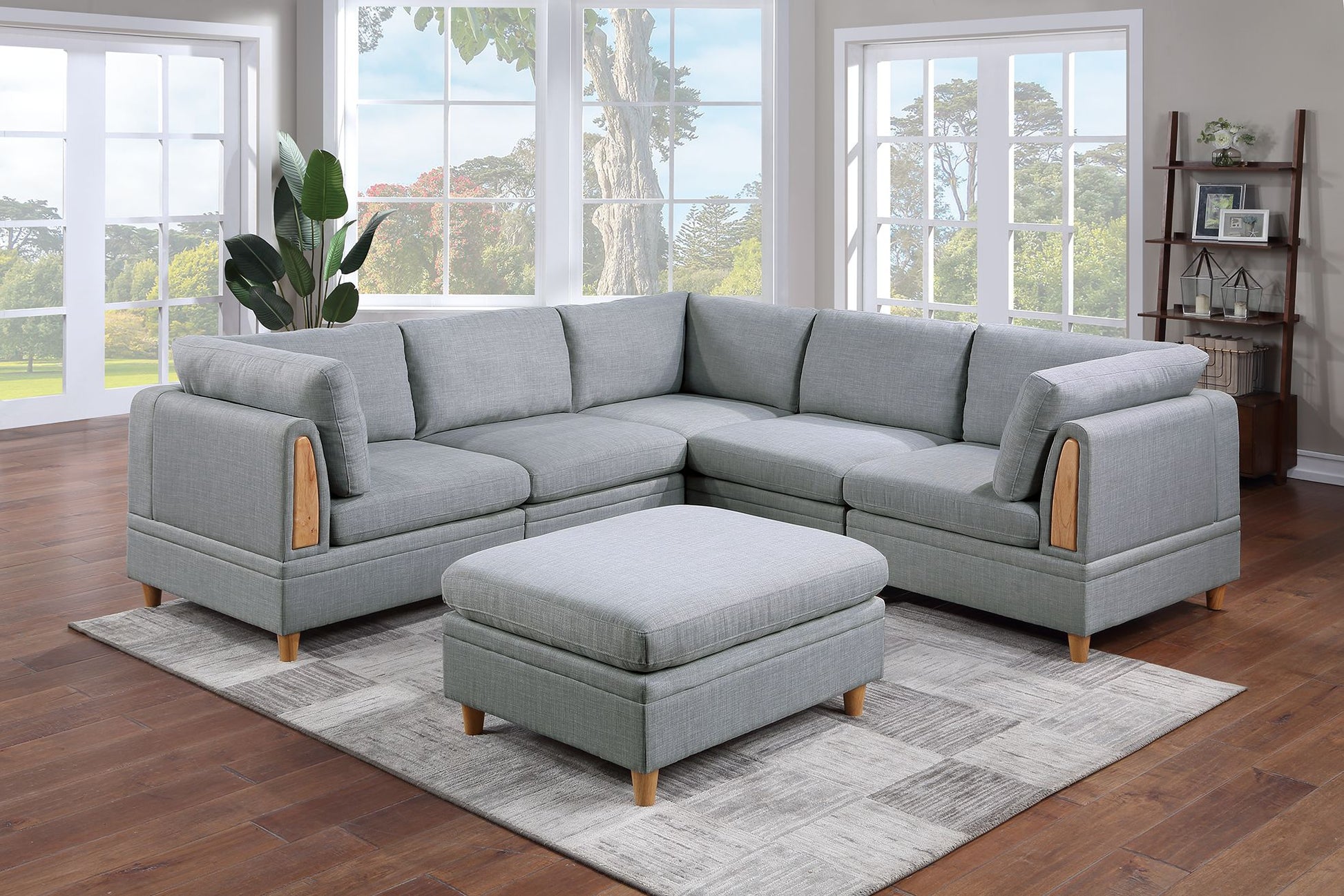 Light grey fabric sectional sofa with wooden accents and matching ottoman