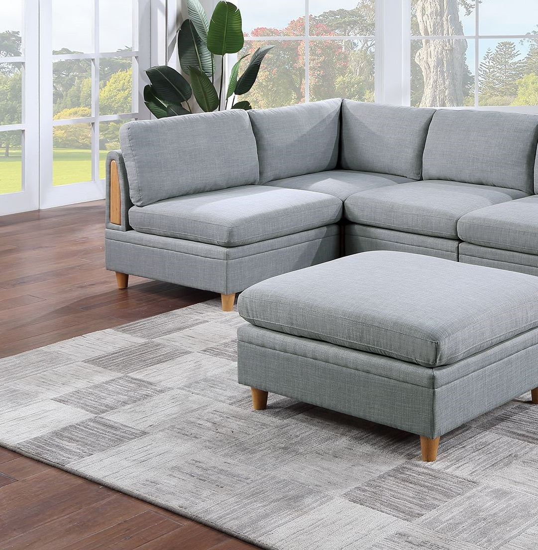 Light gray fabric sectional sofa with wooden legs and an ottoman