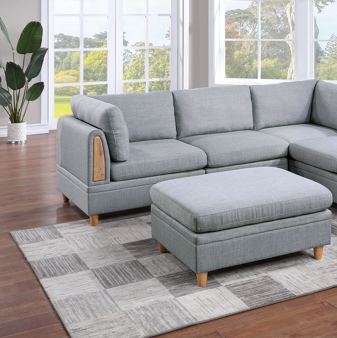 Modern grey fabric sectional sofa with wooden arm accent and matching storage ottoman