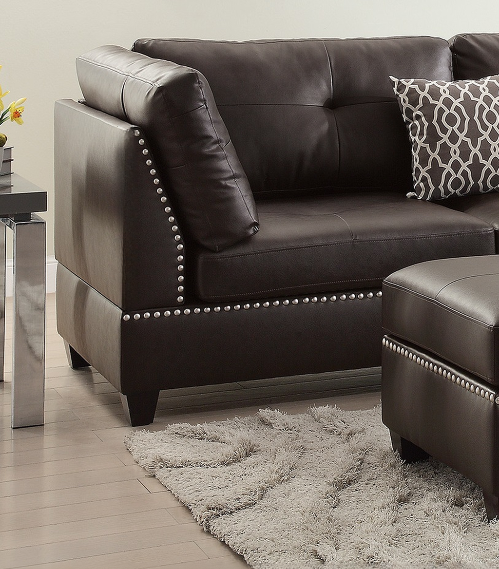 Dark brown leather sectional sofa with studded trim and accent pillow