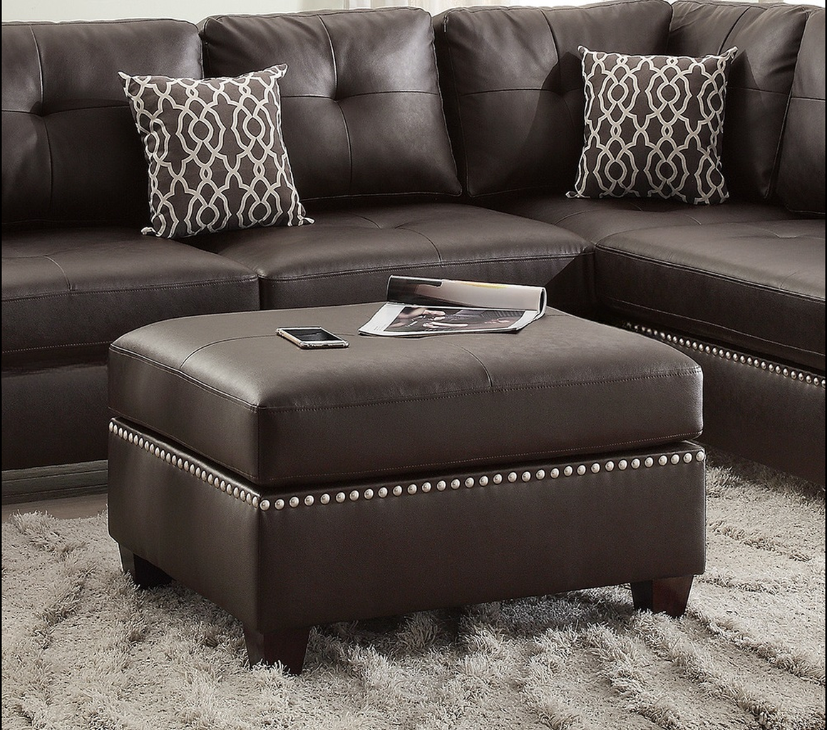Brown leather ottoman with silver nailhead trim and plush rug