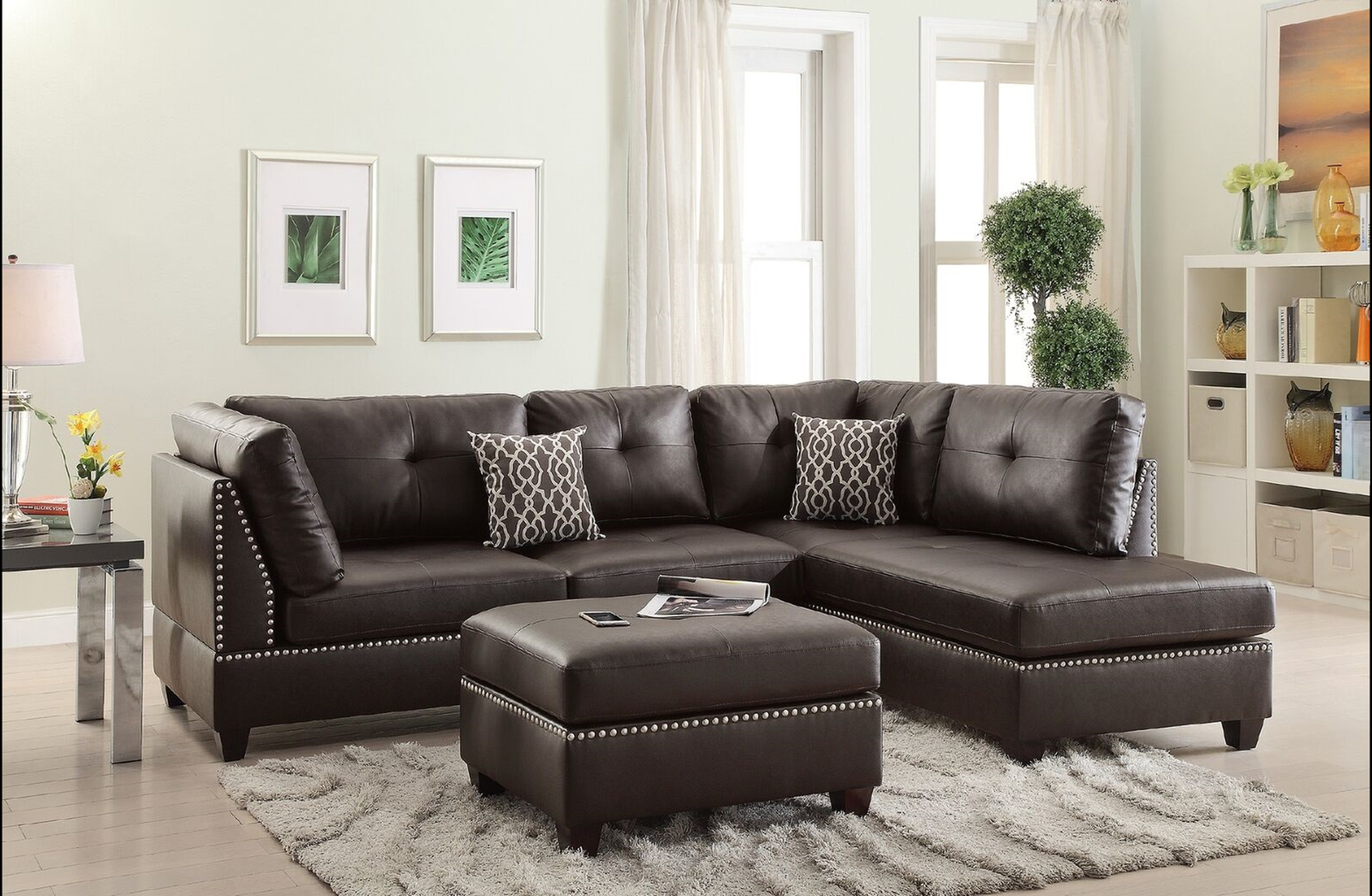 Dark brown tufted leather sectional sofa with silver nailhead trim and matching ottoman