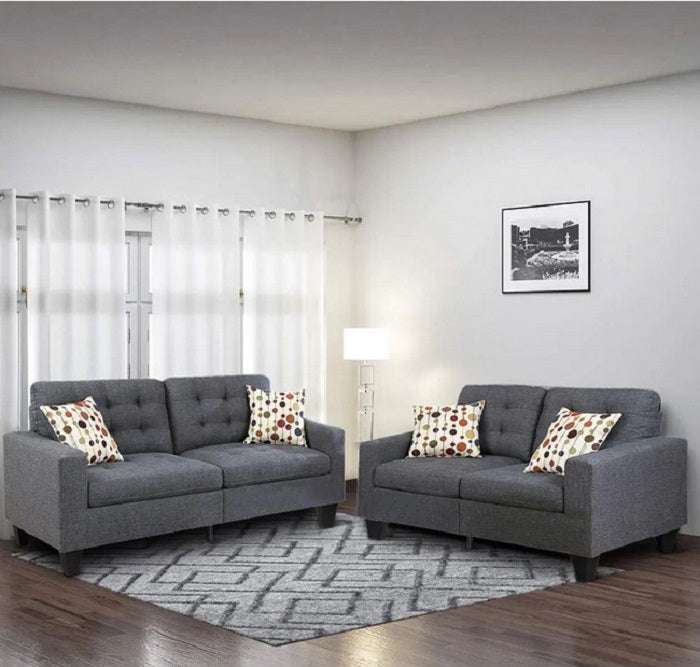 Two modern charcoal gray sofas with decorative pillows in a living room setting