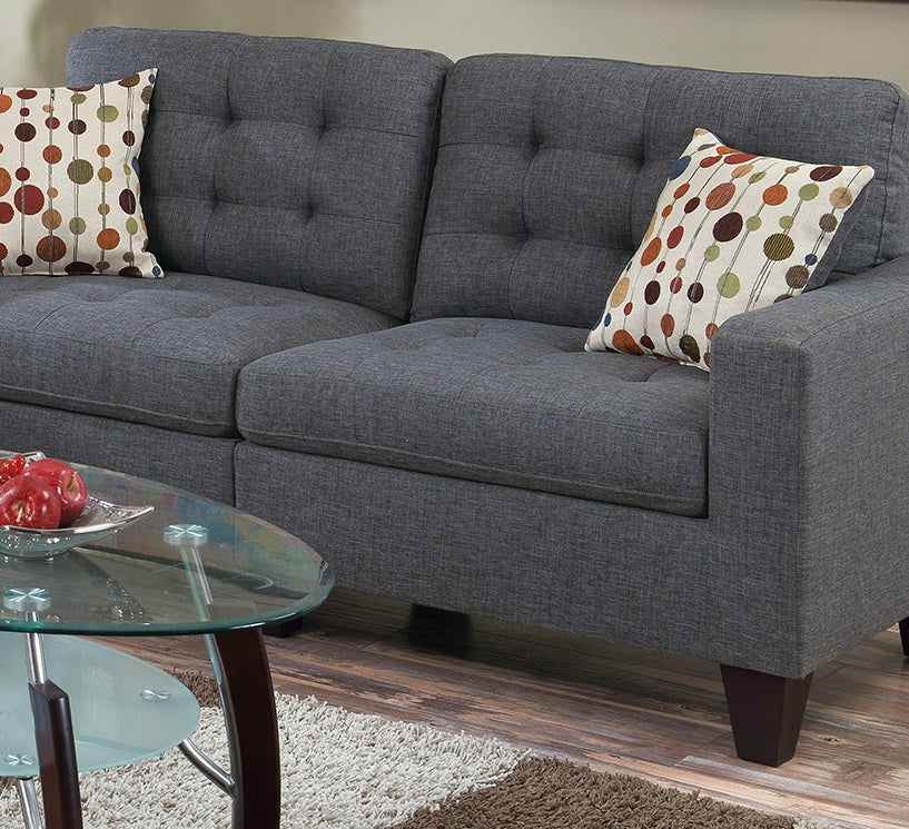 Dark gray tufted loveseat with patterned accent pillows for modern living room