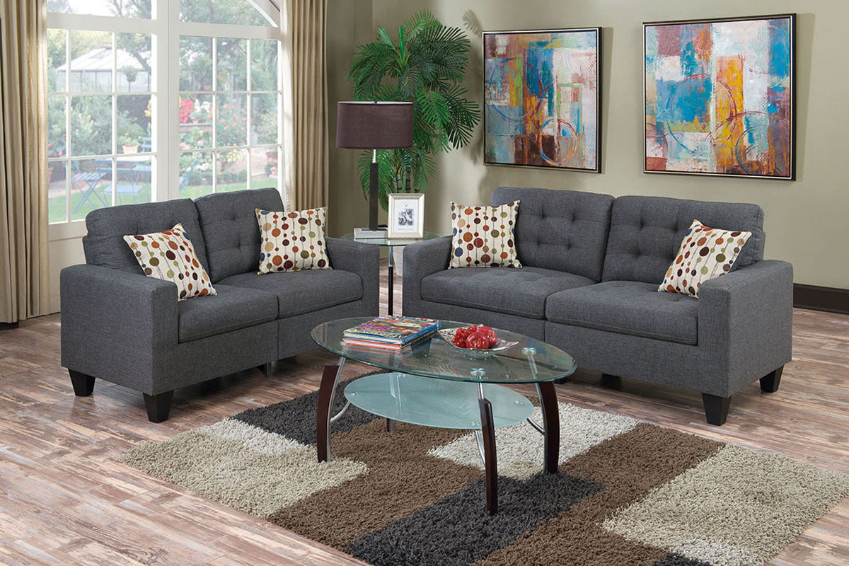 Dark gray fabric loveseat with tufted back and patterned throw pillows