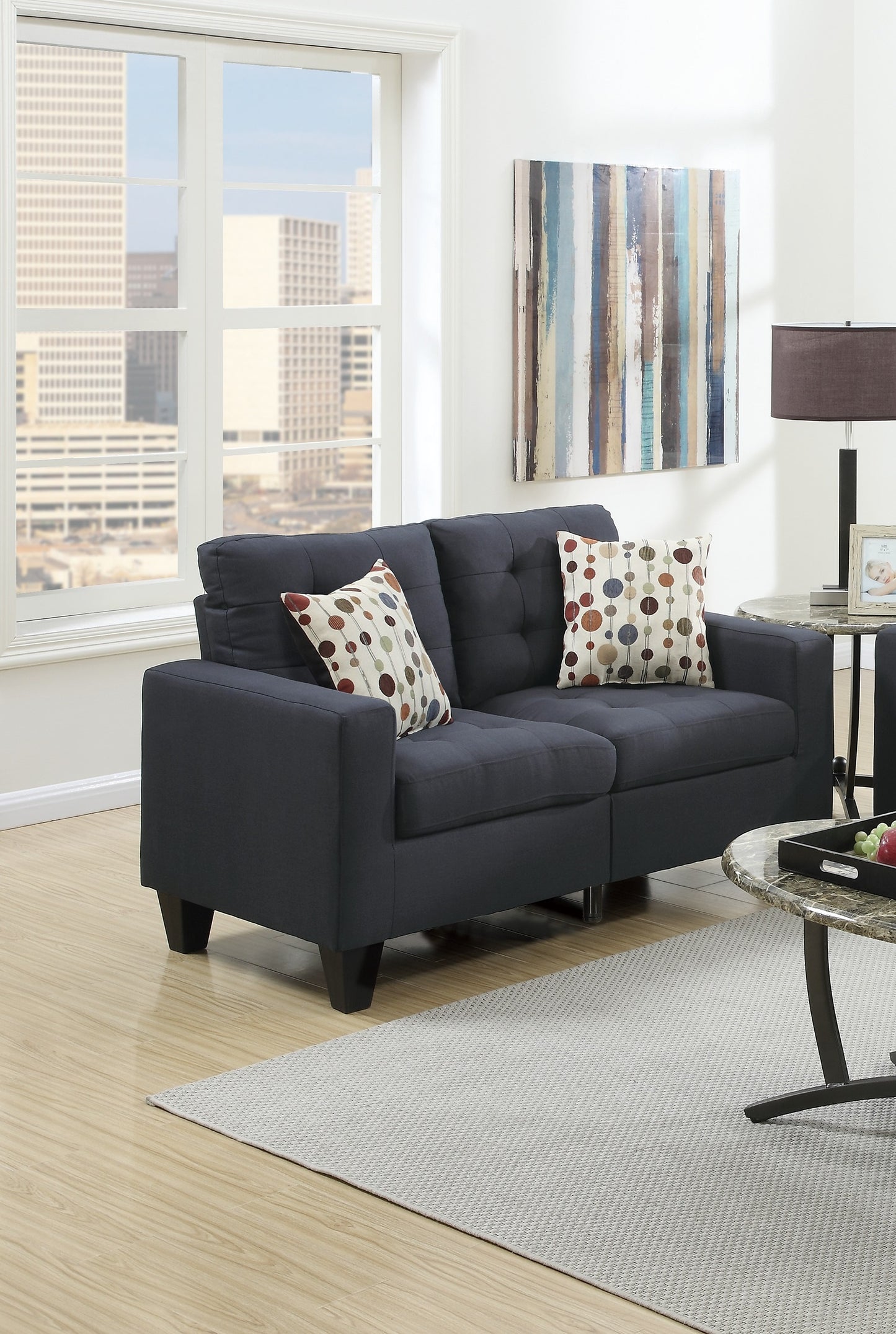 Dark navy tufted loveseat with patterned throw pillows in a living room setting