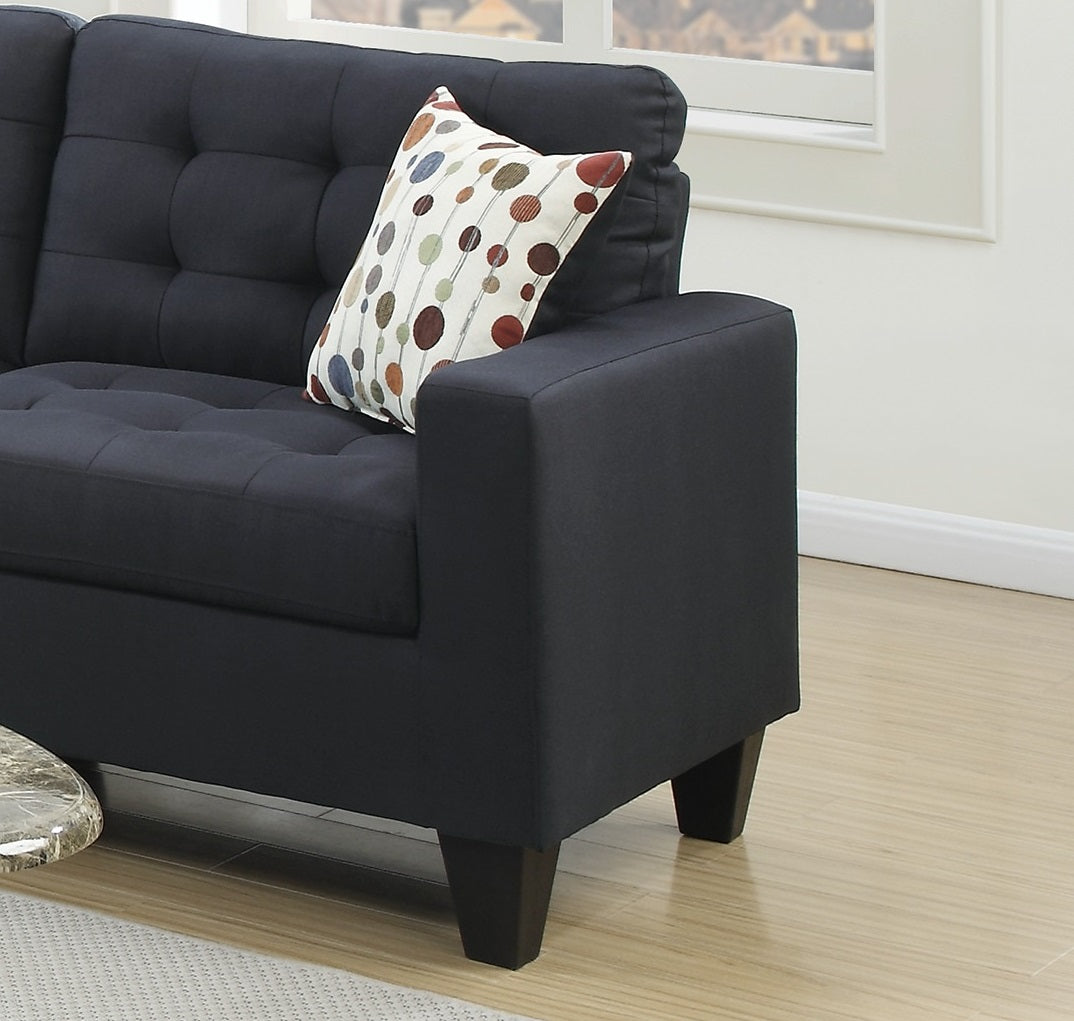 Dark navy tufted sofa with a modern geometric accent pillow for living room comfort