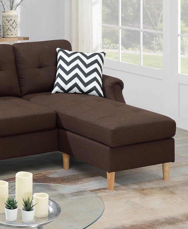 Brown fabric sectional sofa with tufted cushions and a chevron accent pillow