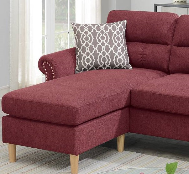 Burgundy fabric sectional sofa with decorative nailhead trim and a geometric throw pillow