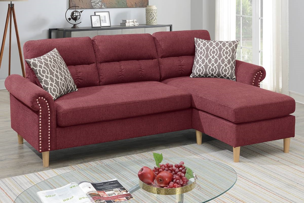 Deep red fabric sectional sofa with tufted back cushions and decorative nailhead trim