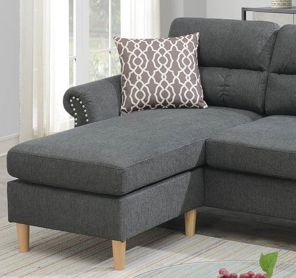 Dark gray fabric chaise lounge with decorative nailhead trim and patterned throw pillow