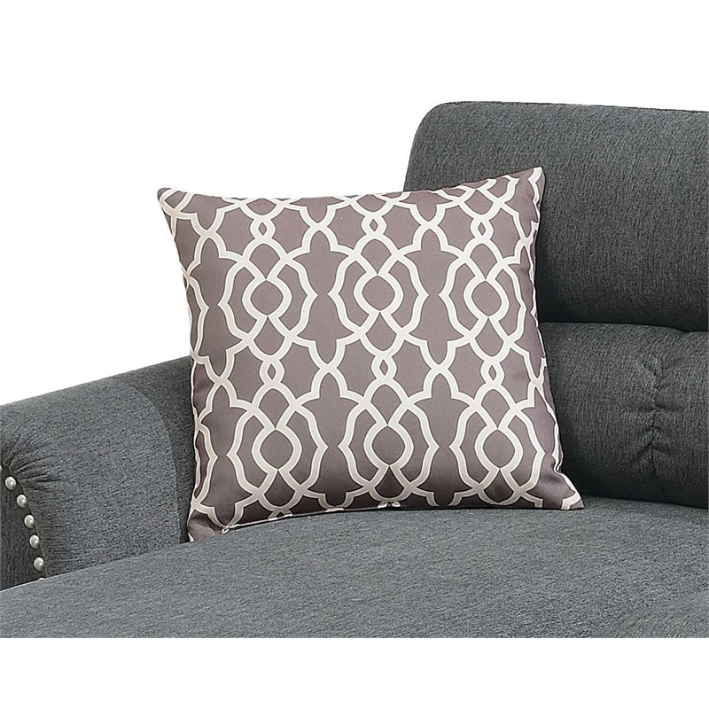 Gray geometric accent pillow with white interlocking pattern on a charcoal sofa