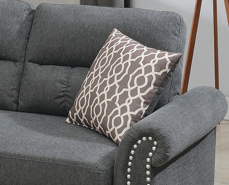 Dark gray upholstered sofa with tufted back cushions and a decorative pillow
