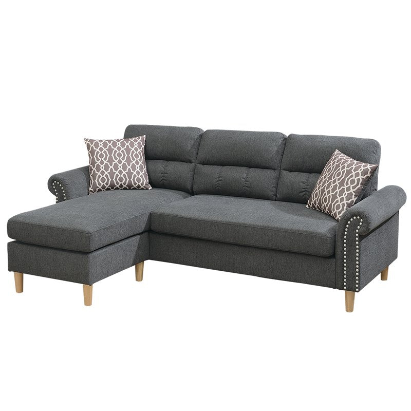 Dark grey fabric sectional sofa with decorative tufting and nailhead trim