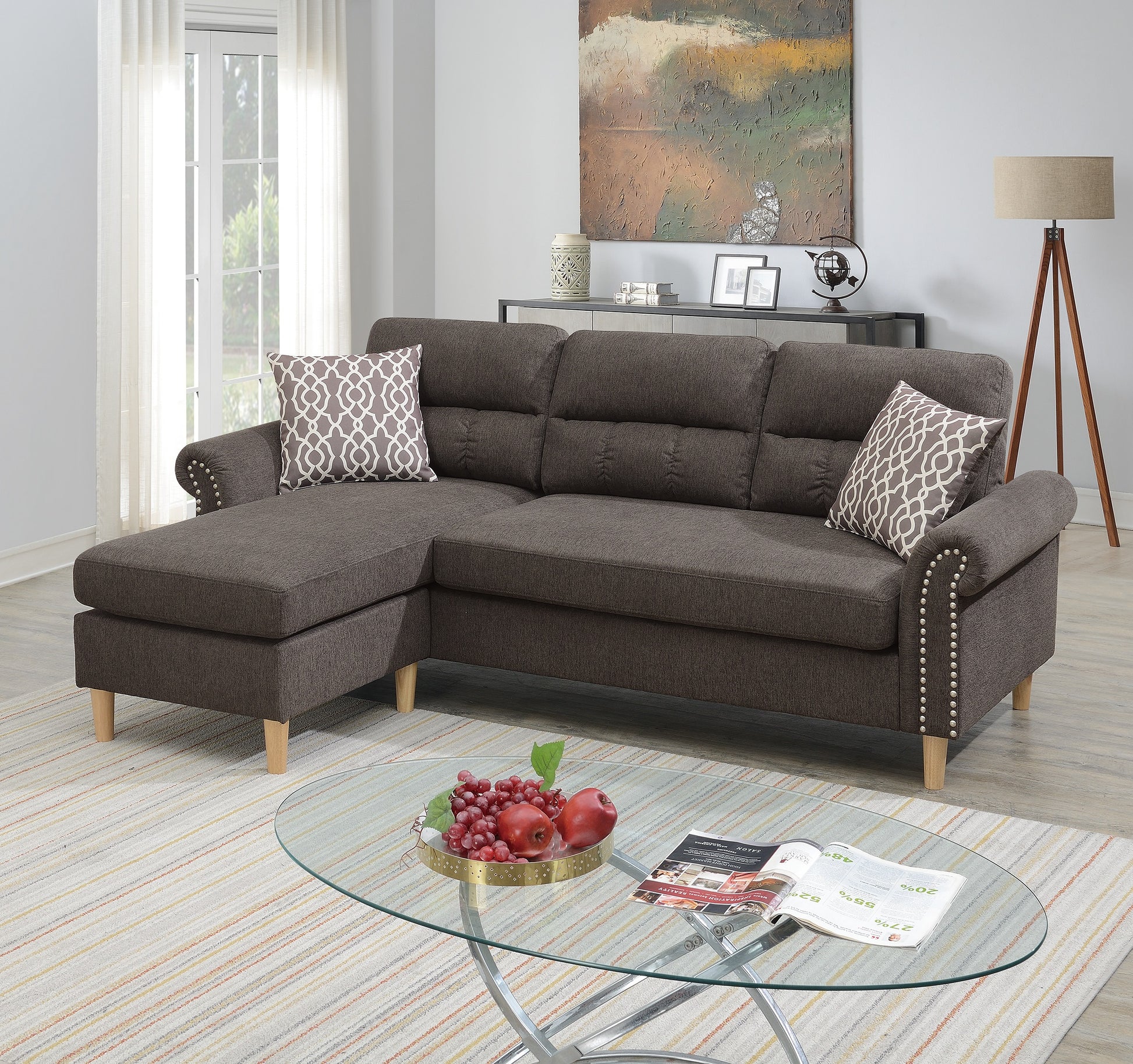 Dark grey upholstered sectional sofa with nailhead trim and decorative pillows