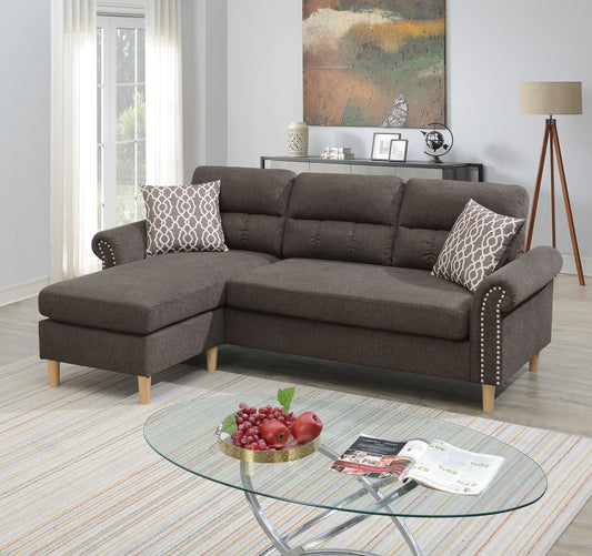 Dark grey upholstered sectional sofa with nailhead trim and decorative pillows