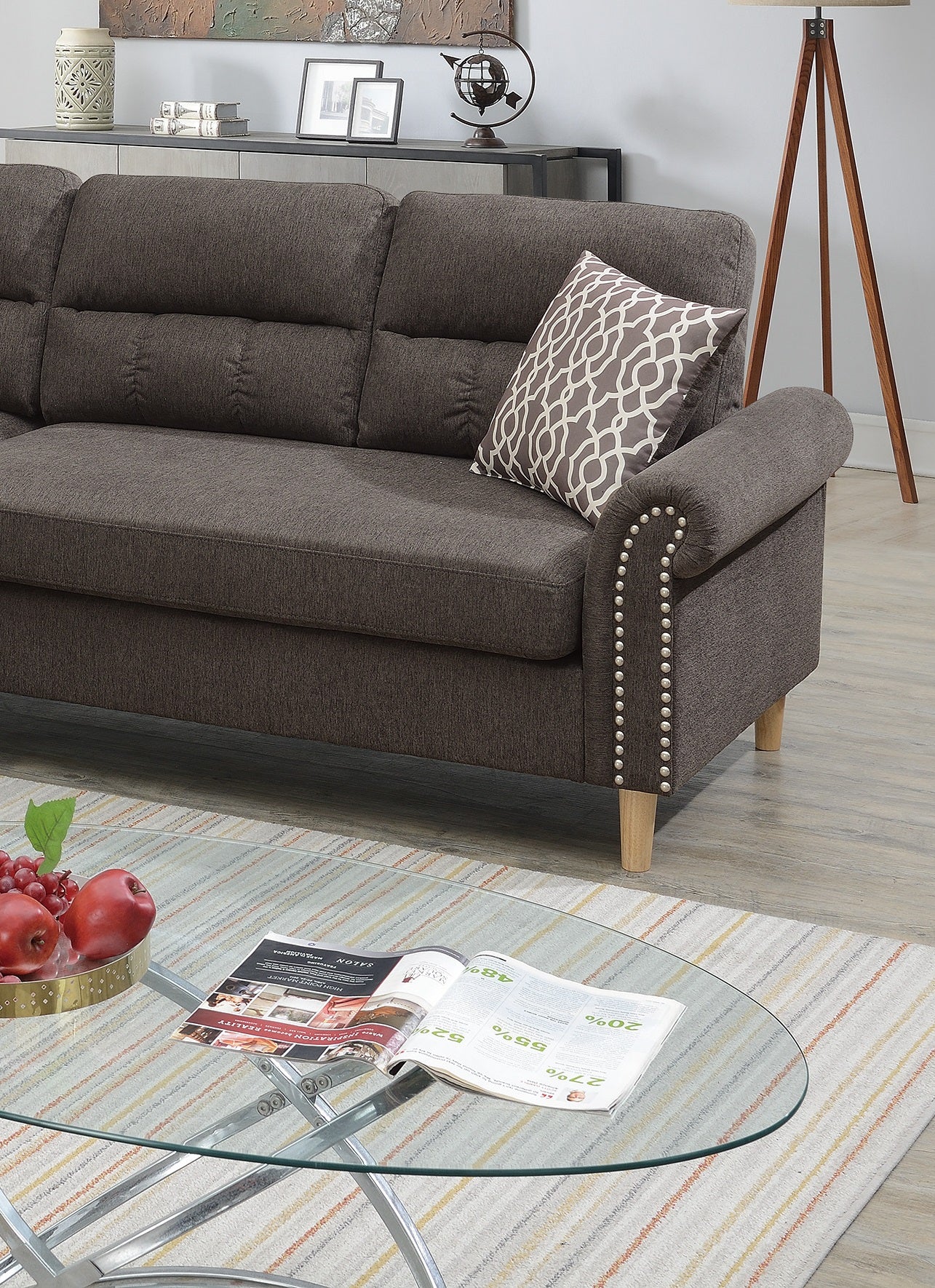 Dark brown fabric sectional sofa with decorative nailhead trim and a patterned throw pillow