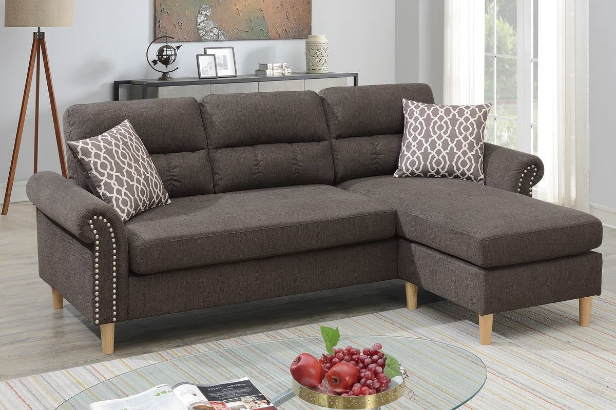 Dark gray fabric sectional sofa with nailhead trim and geometric patterned pillows