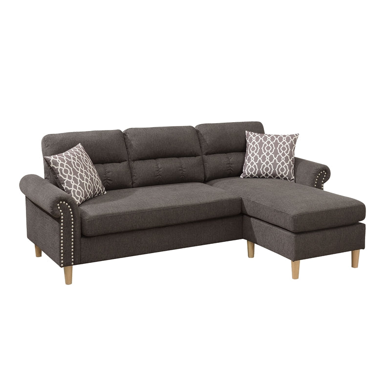 Dark gray fabric sectional sofa with decorative nailhead trim and patterned throw pillows