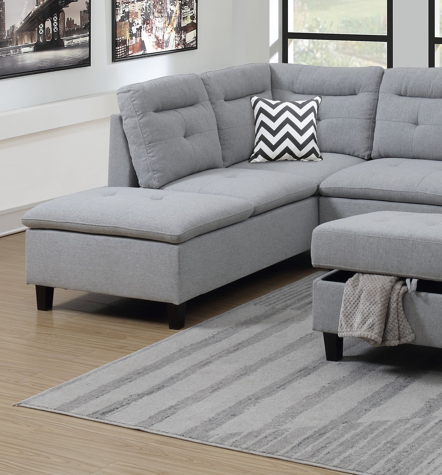 Gray fabric sectional sofa with tufted back cushions and chevron pillow