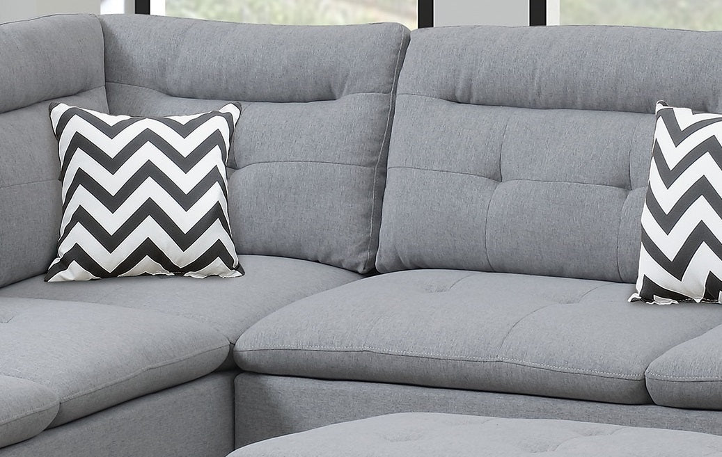 Grey fabric sectional sofa with two chevron throw pillows for living room comfort