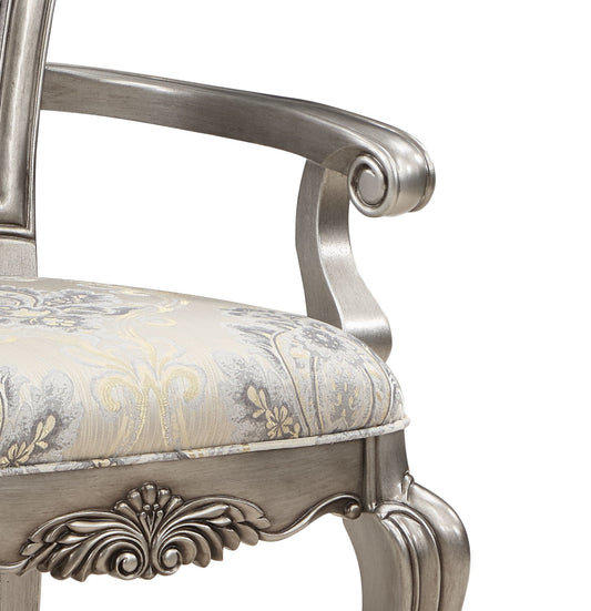 Silver ornate armchair with damask patterned seat and carved wooden legs