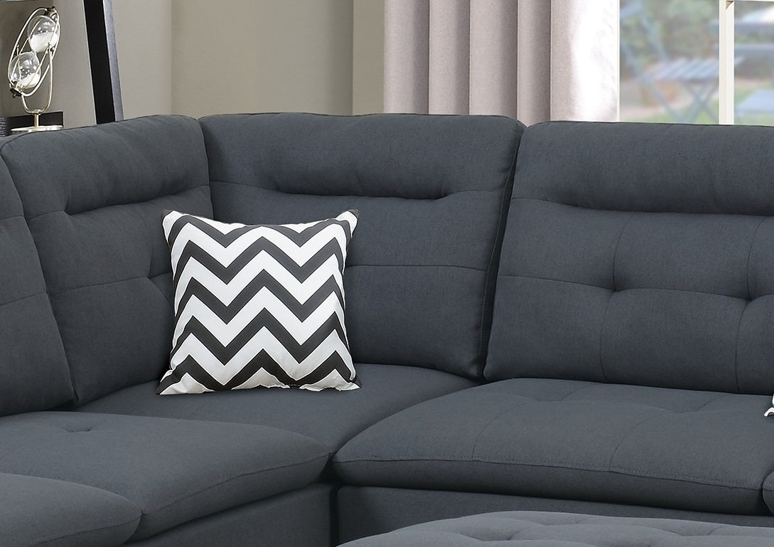 Dark gray sectional sofa with a black and white chevron throw pillow accent