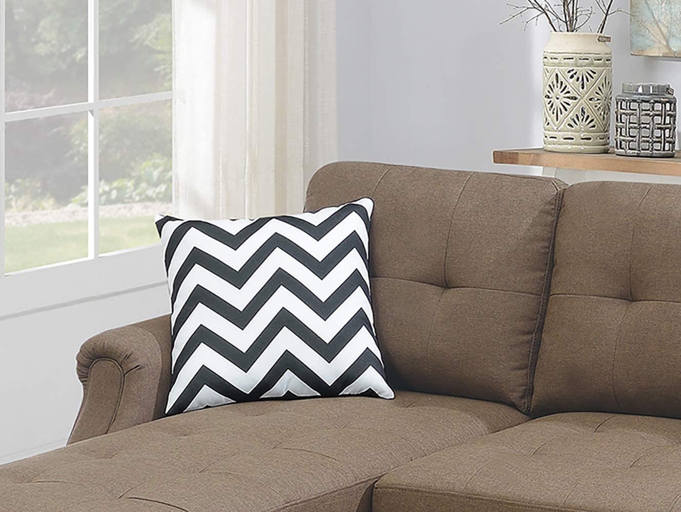 Black and white chevron throw pillow with modern zigzag pattern on brown sofa