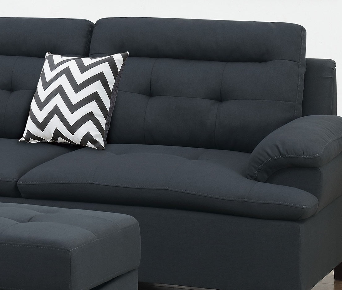 Dark gray fabric sofa with tufted cushions and a chevron throw pillow