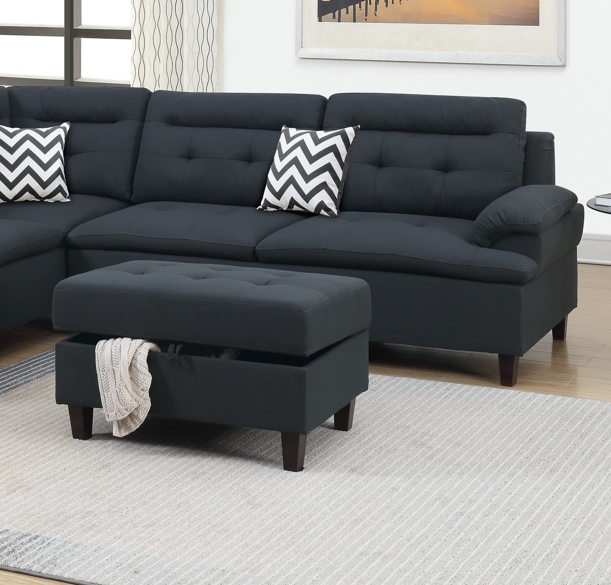 Dark charcoal sectional sofa with tufted cushions and decorative chevron pillows for modern living rooms