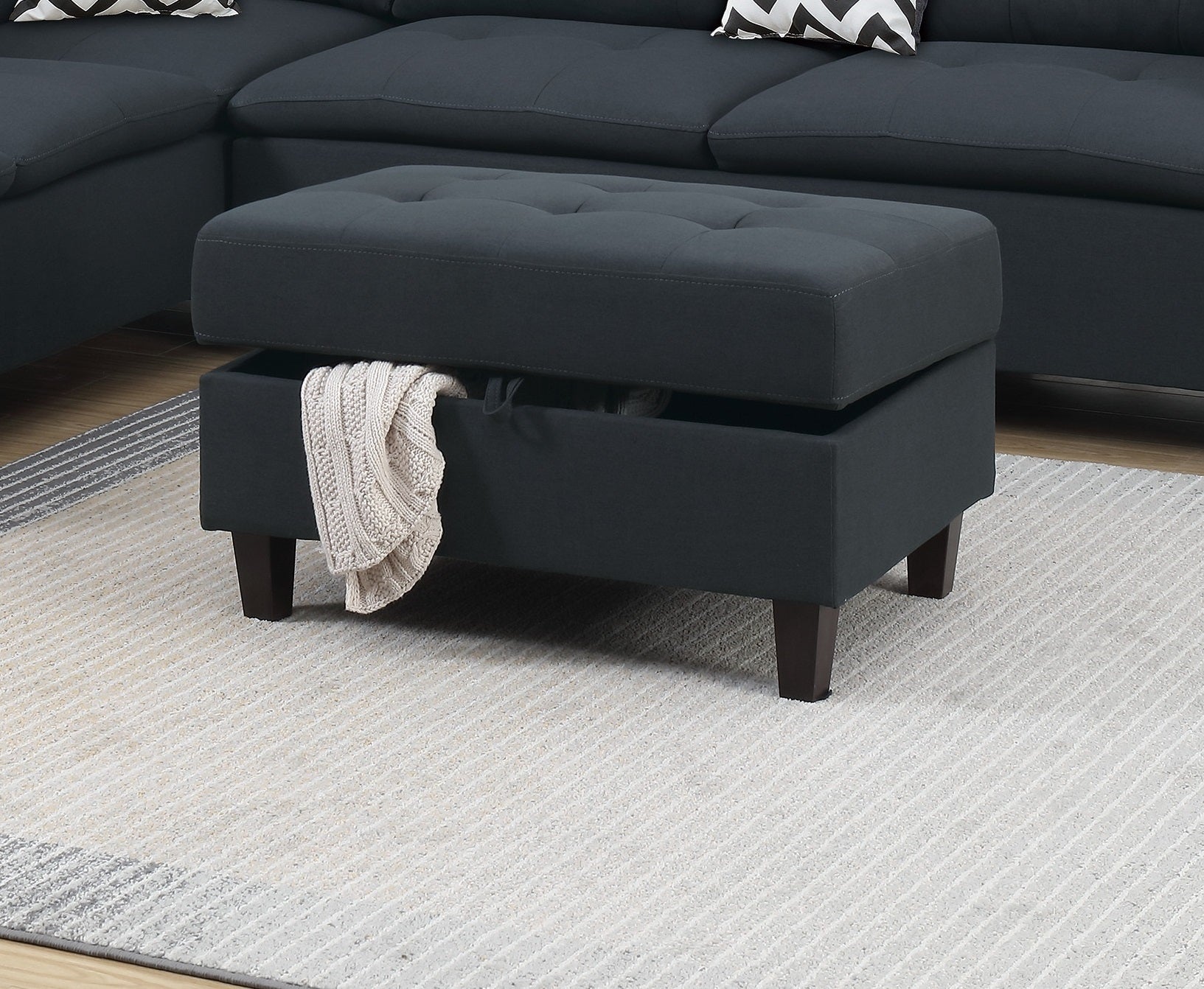 Tufted dark gray fabric storage ottoman with wooden legs perfect for living room organization