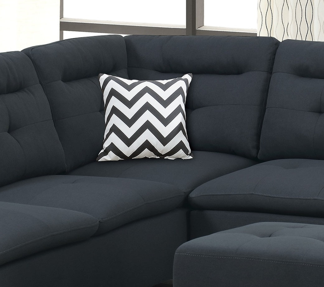 Tufted charcoal sectional sofa with a black and white chevron throw pillow