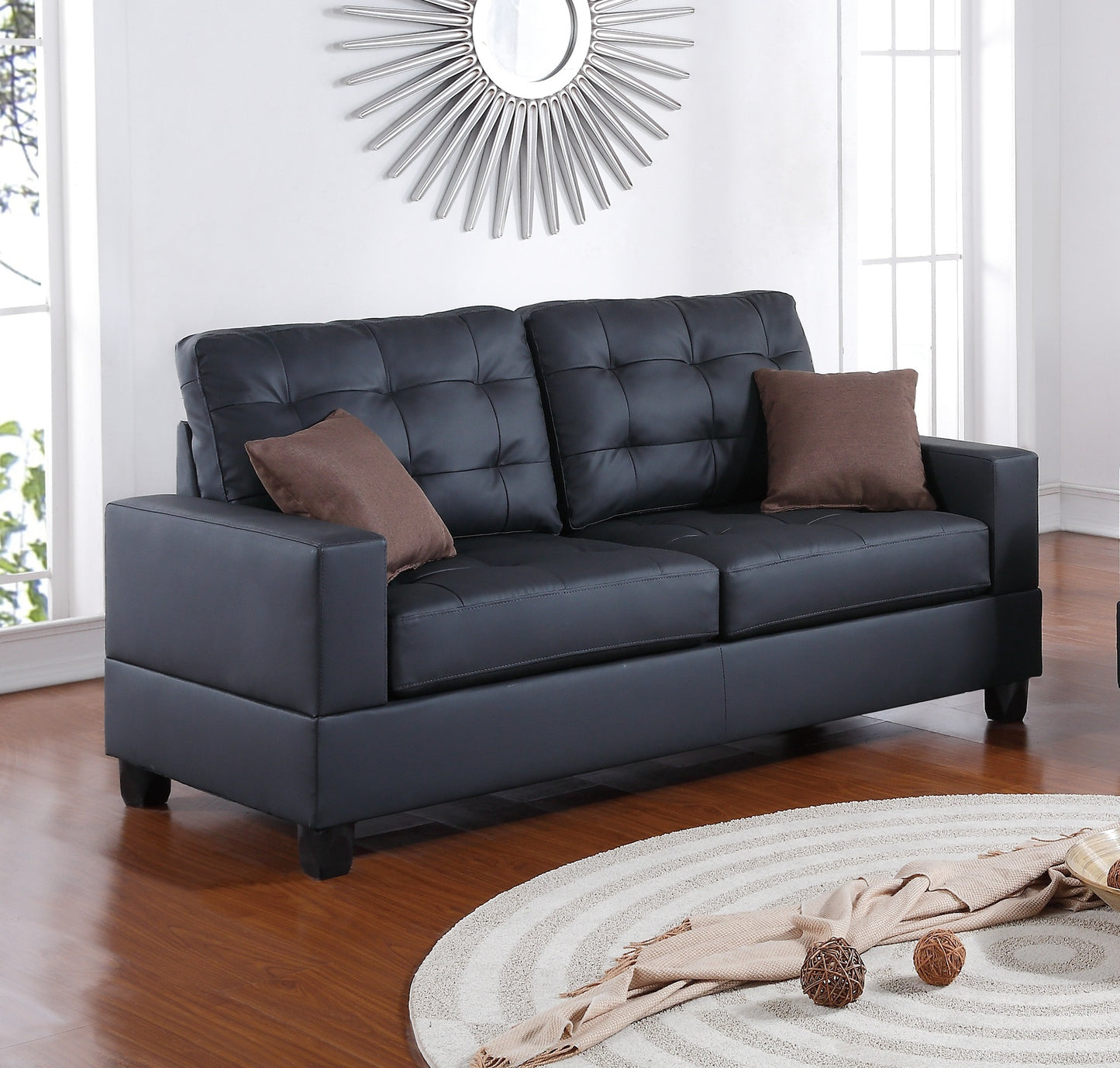 Black faux leather tufted loveseat with square arms and brown accent pillows