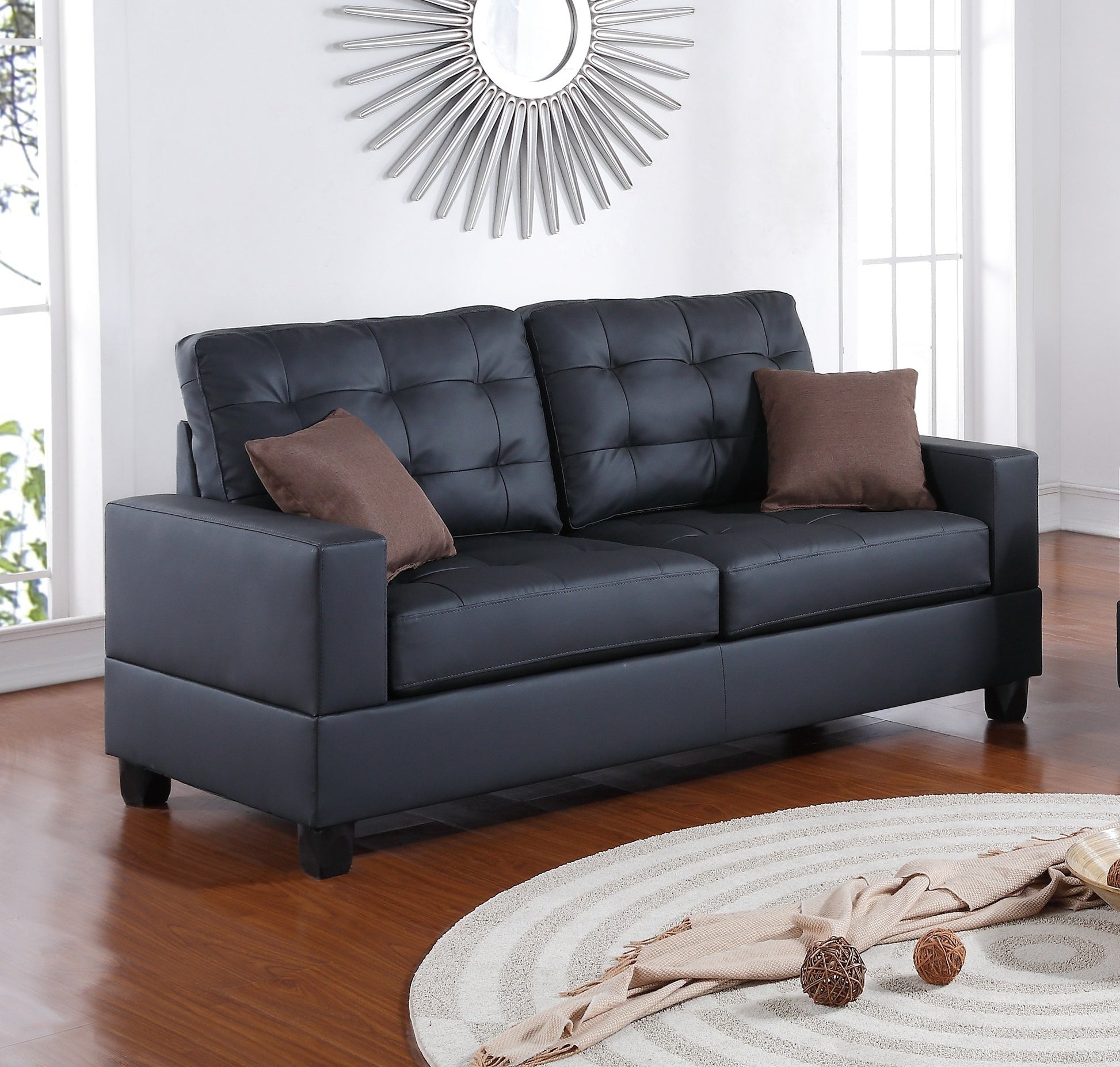 Black faux leather tufted loveseat with square arms and brown accent pillows