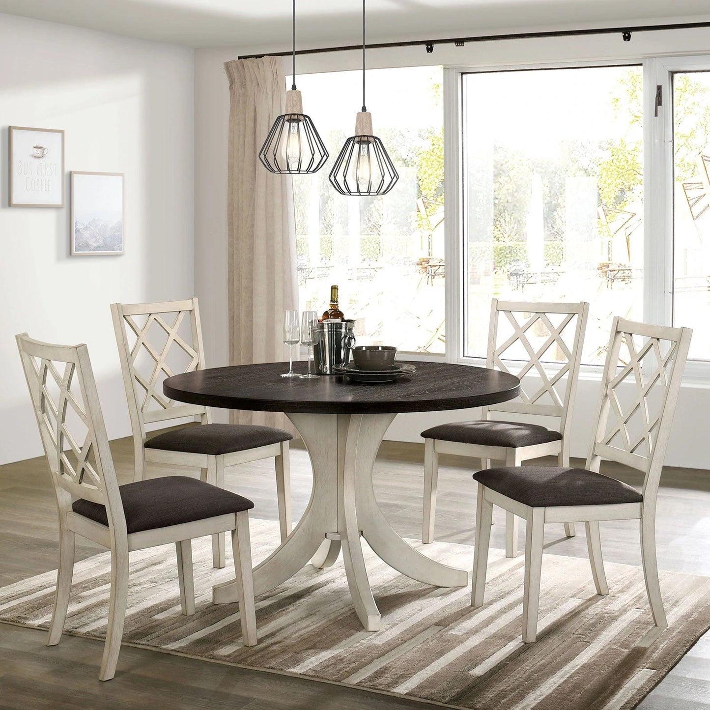 Round dining table with dark wood top and pedestal base seats four in cream chairs