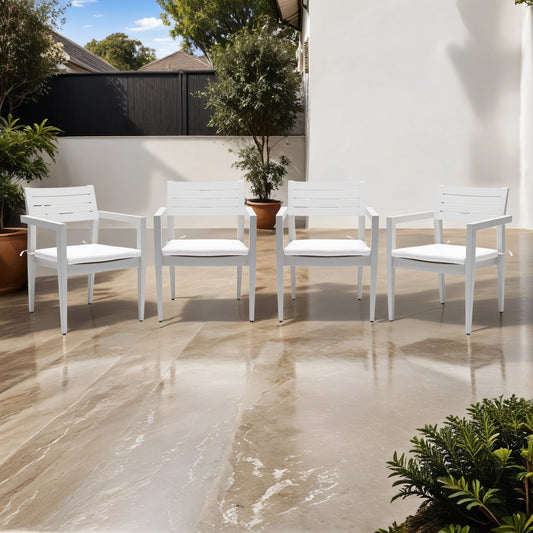 Four white modern outdoor armchairs with plush cushions on a marble patio