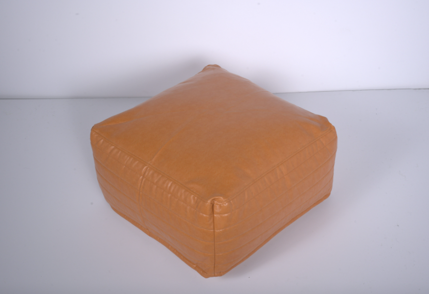 Tan leather tufted square pouf providing comfortable footrest or extra seating