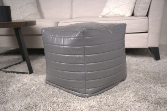 Grey faux leather ottoman with horizontal stitching and cushioned top