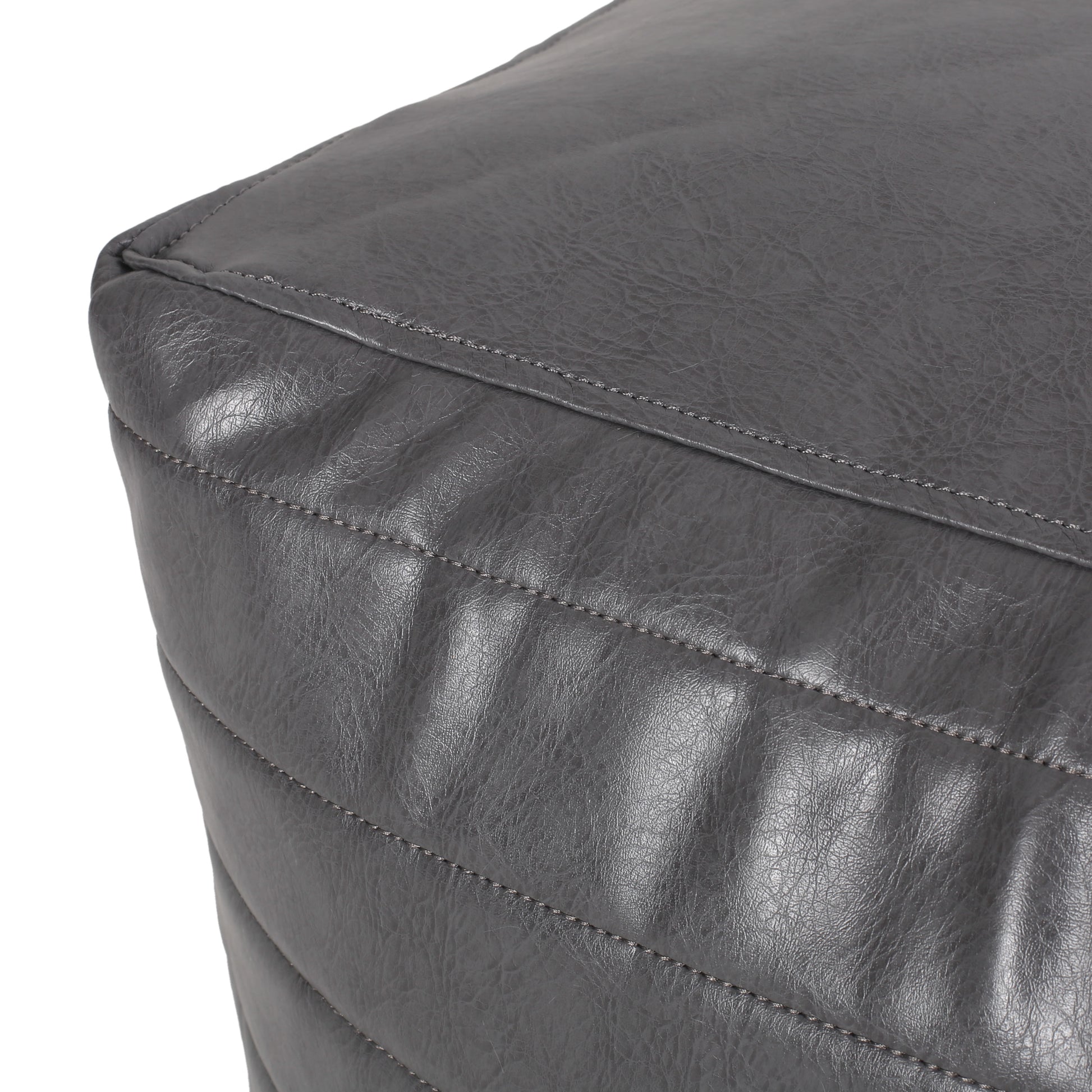 Quilted charcoal faux leather ottoman corner with subtle stitching detail