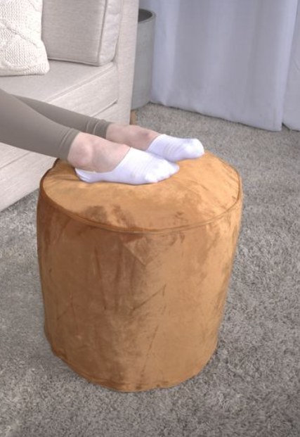 Round velvet ottoman in warm brown perfect as a footrest for comfortable living room seating
