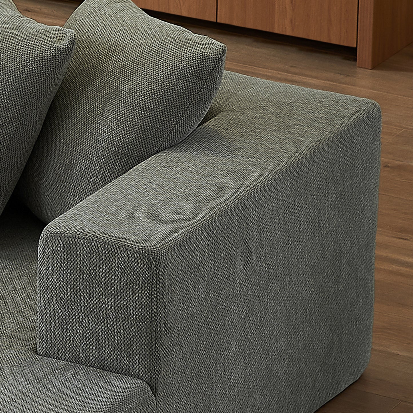 Closeup of a grey woven fabric sofa armrest with textured detail