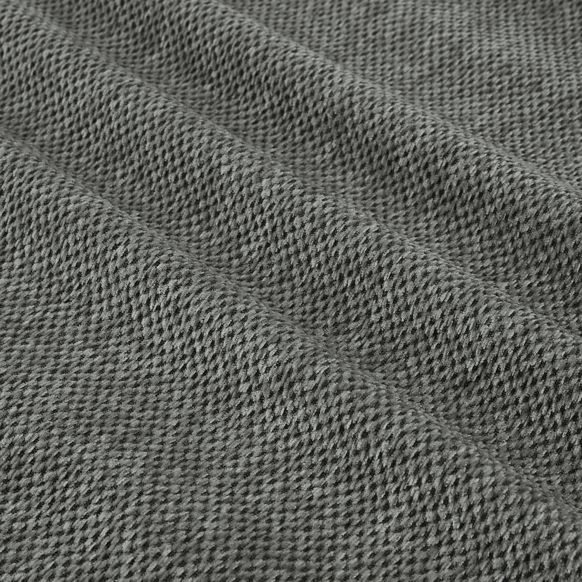 Closeup texture of a grey knitted fabric with visible loops and a soft plush feel ideal for cozy apparel