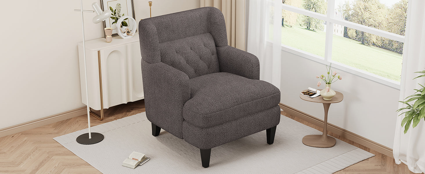 Plush dark gray accent chair with tufted back and rounded arms for a cozy living room