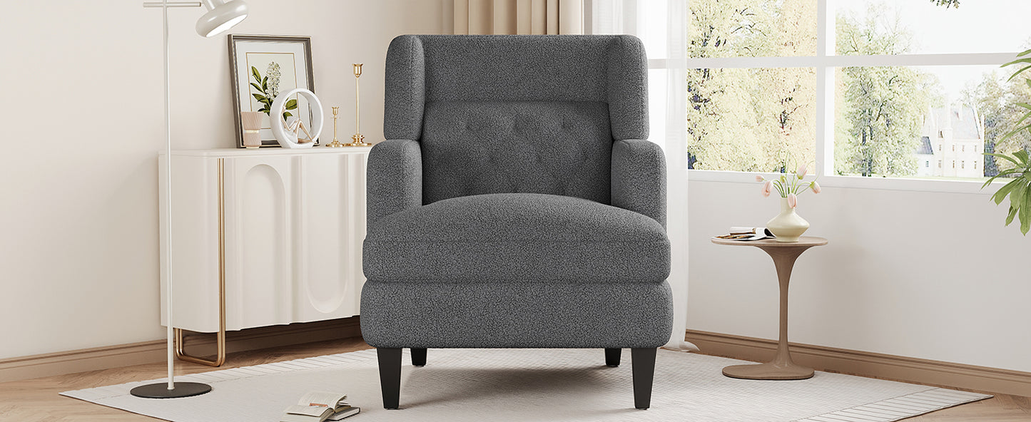 Dark gray boucle accent chair with button tufting and black tapered legs