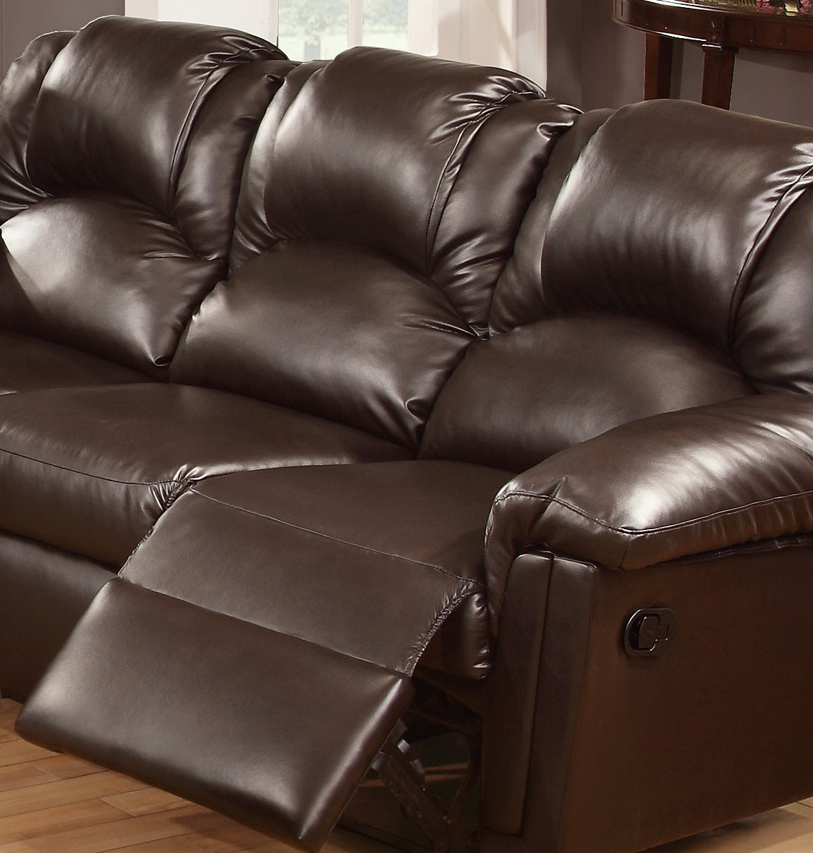 Dark brown faux leather threeseater recliner sofa with plush cushions