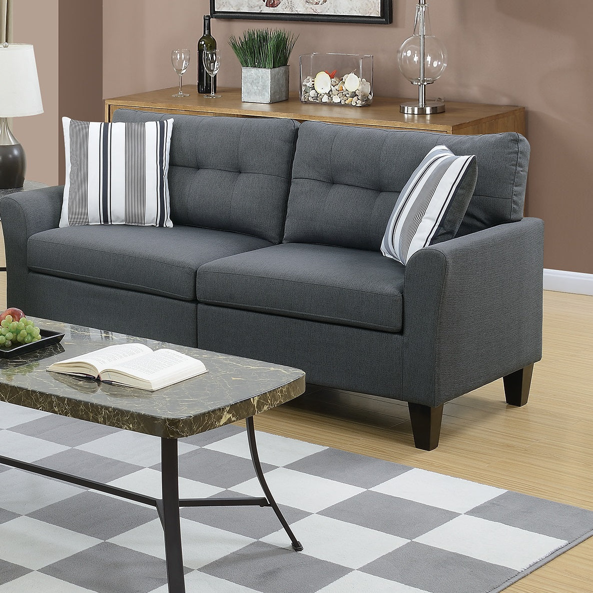 Dark gray upholstered sofa with tufted back cushions and decorative pillows