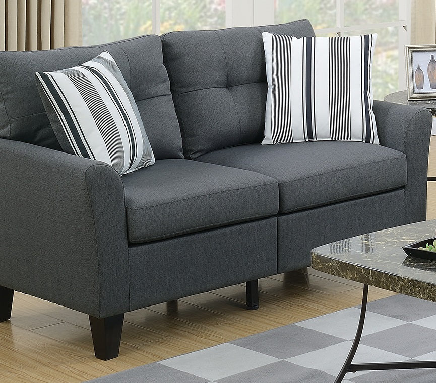 Charcoal grey upholstered twoseater sofa with tufted back cushions and decorative pillows