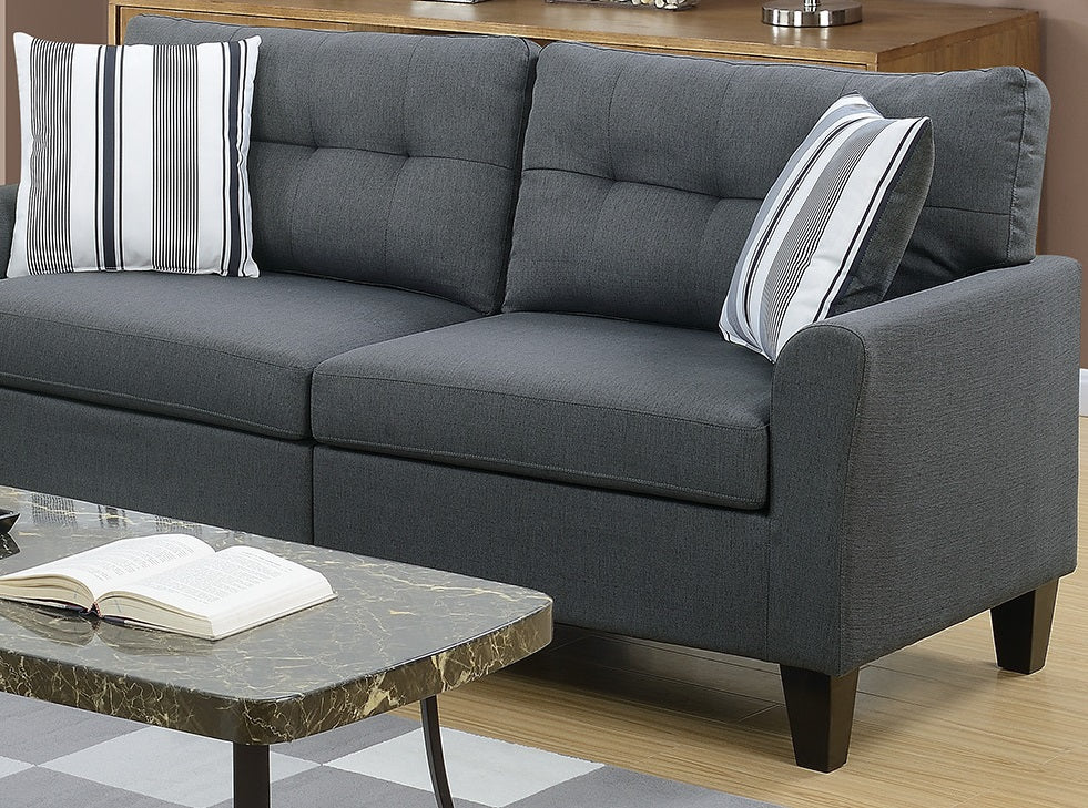 Dark gray fabric sectional sofa with tufted back cushions and striped throw pillows