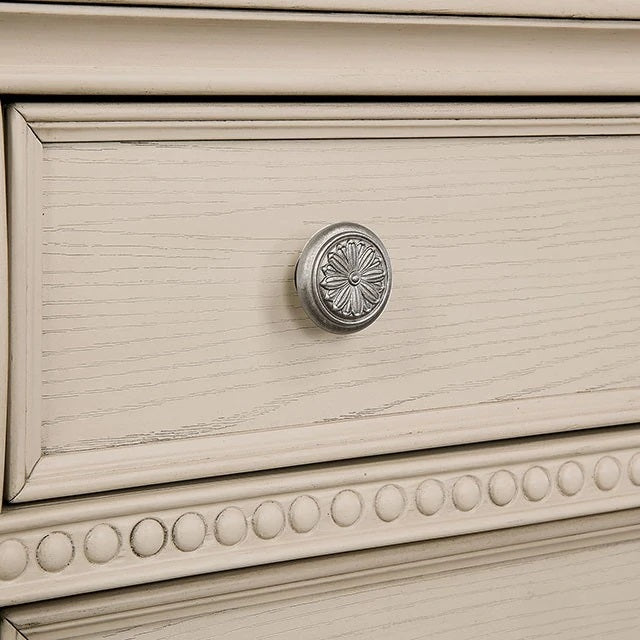 Ornate silver drawer knob on distressed cream dresser